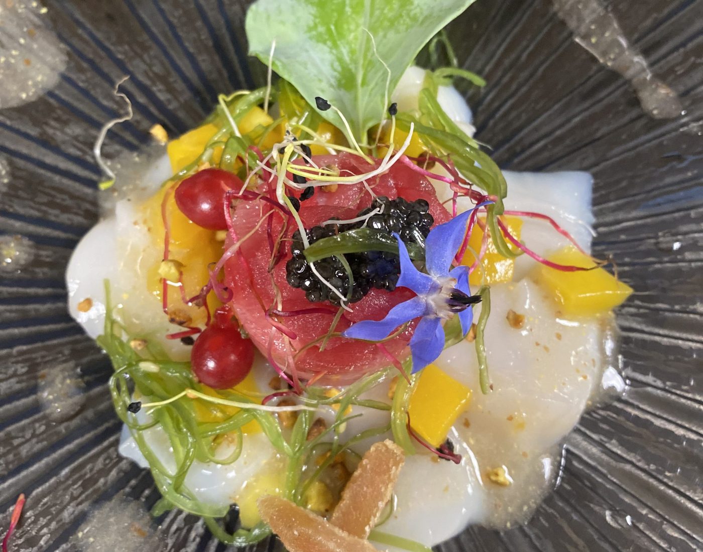 Assiette dressée : carpaccio, fleurs et herbes fraîches